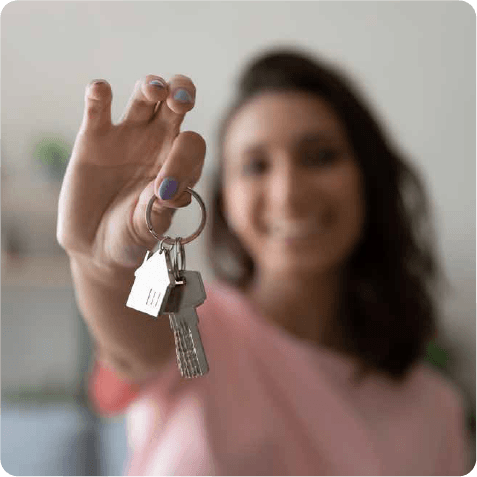young woman holding up a house key to the camera